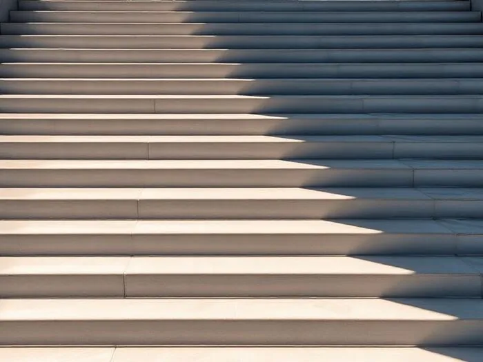 Broad concrete steps crossed by sunlight and shadow.